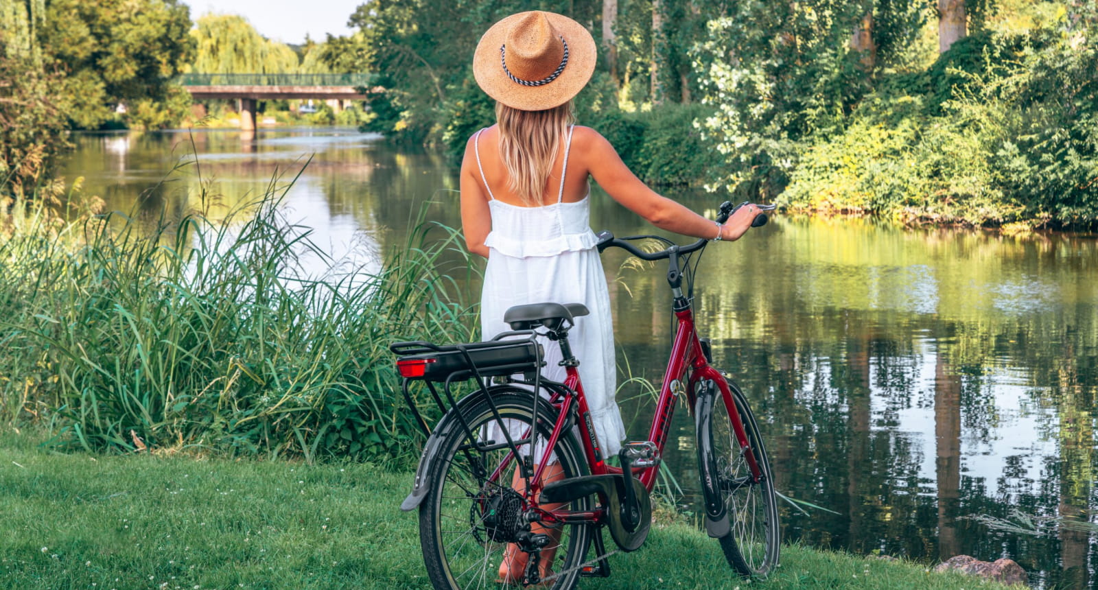 Femme devant le Loir tenant un vélo